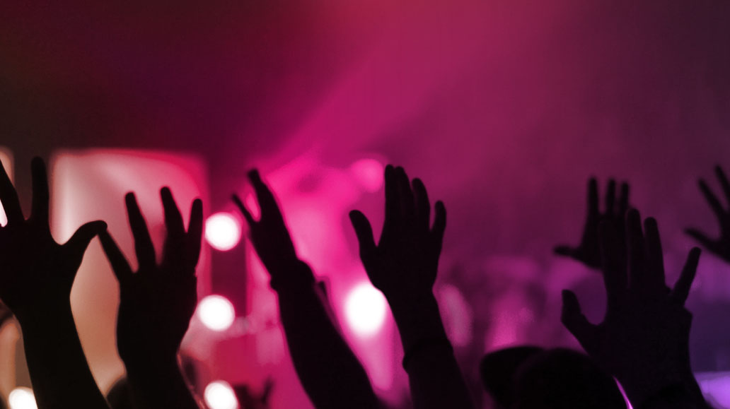 fans with hands in air at concert