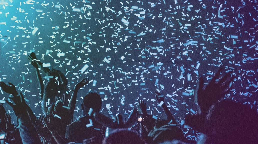 fans cheering at concert with confetti coming down